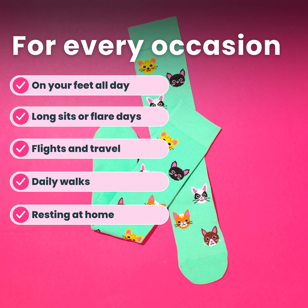 Light green knee high compression socks with cat design flat lay