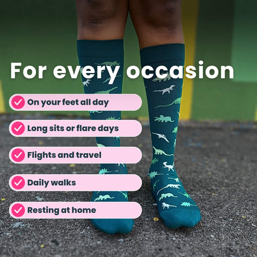 Legs close up wearing green compression socks with a dinosaur pattern
