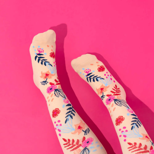 Floral-patterned compression socks on a pink background