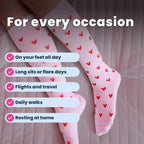 Woman wearing white compression socks with red heart patterns leg close up