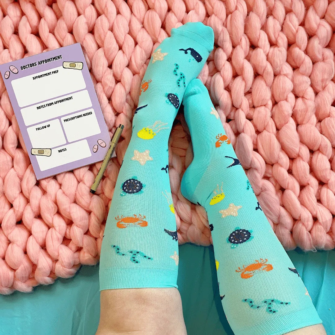 Teal socks with sea creature pattern on a pink textured surface