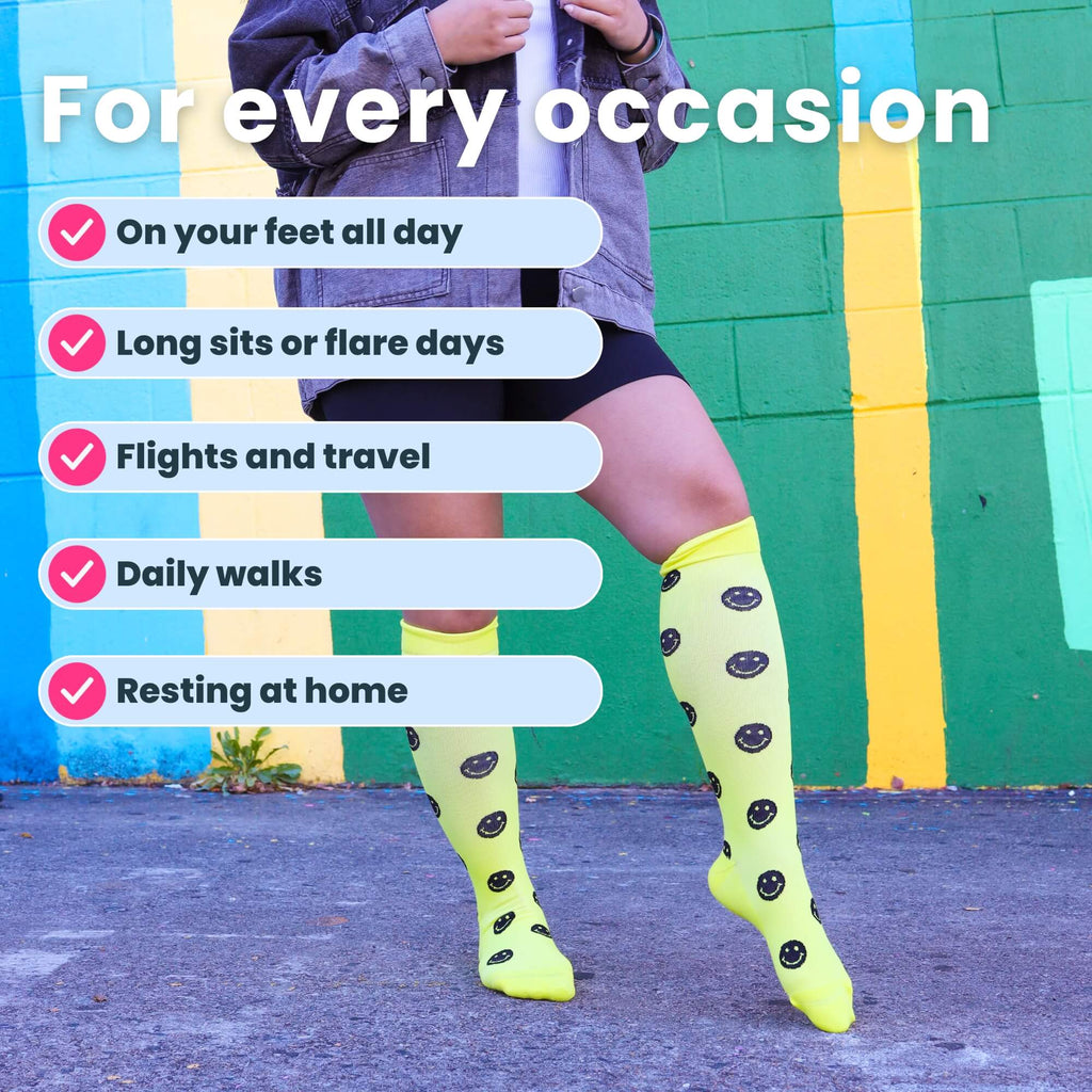 Woman posing in yellow compression socks with black smiley faces